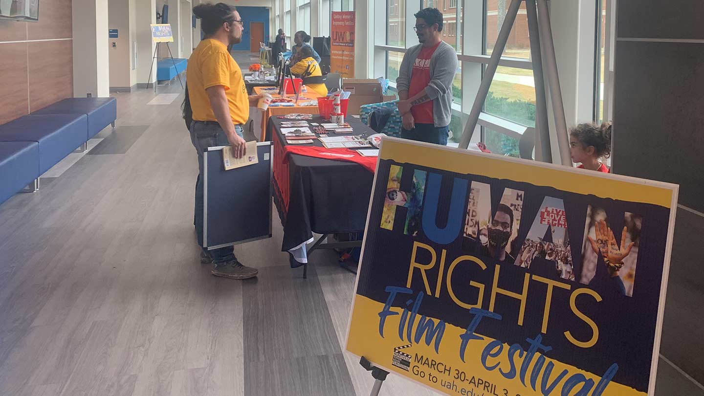 a passerby gets information from a table about human rights