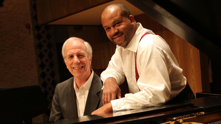 james martin and lynn raley posing and smiling behind a piano