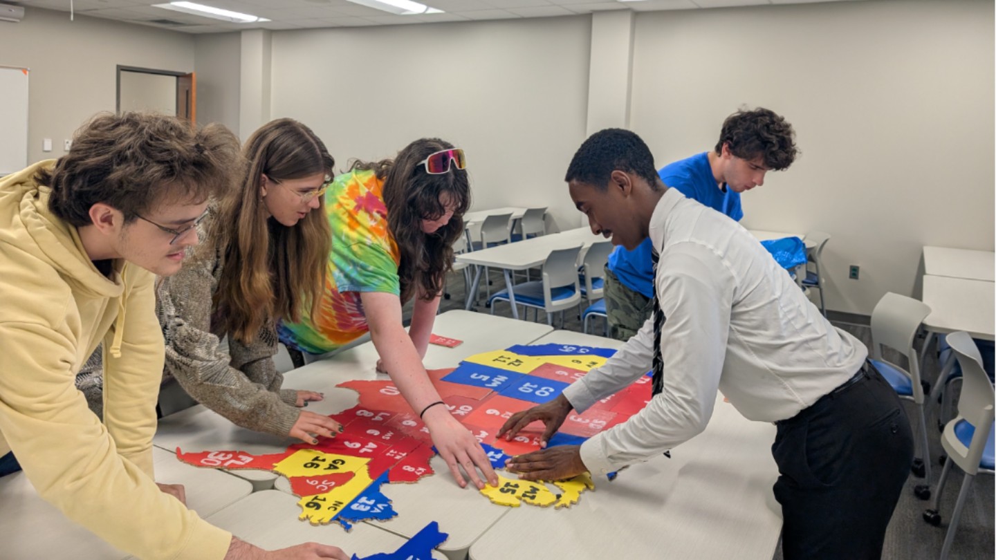 Students putting together map puzzle in Morton Hall