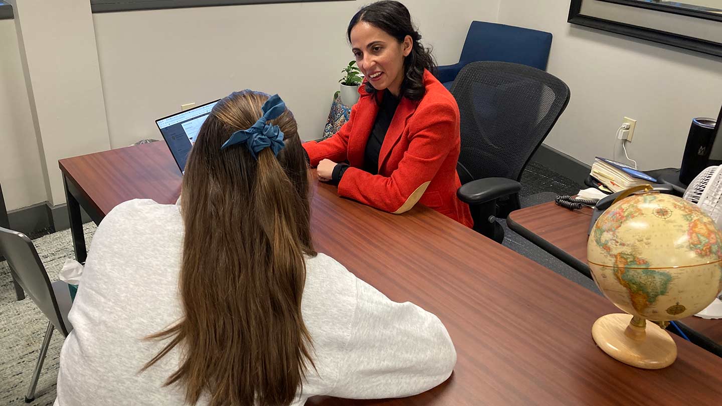 A woman helps a student develop her career internship resume