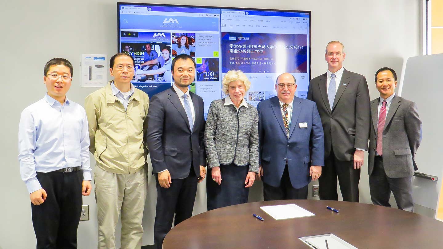 Group photo of UAH and MOOC-CN members standing in a meeting room.