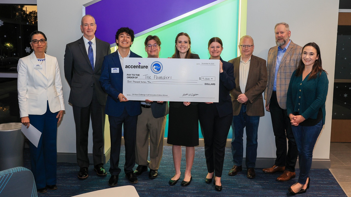 students with large check after winning competition