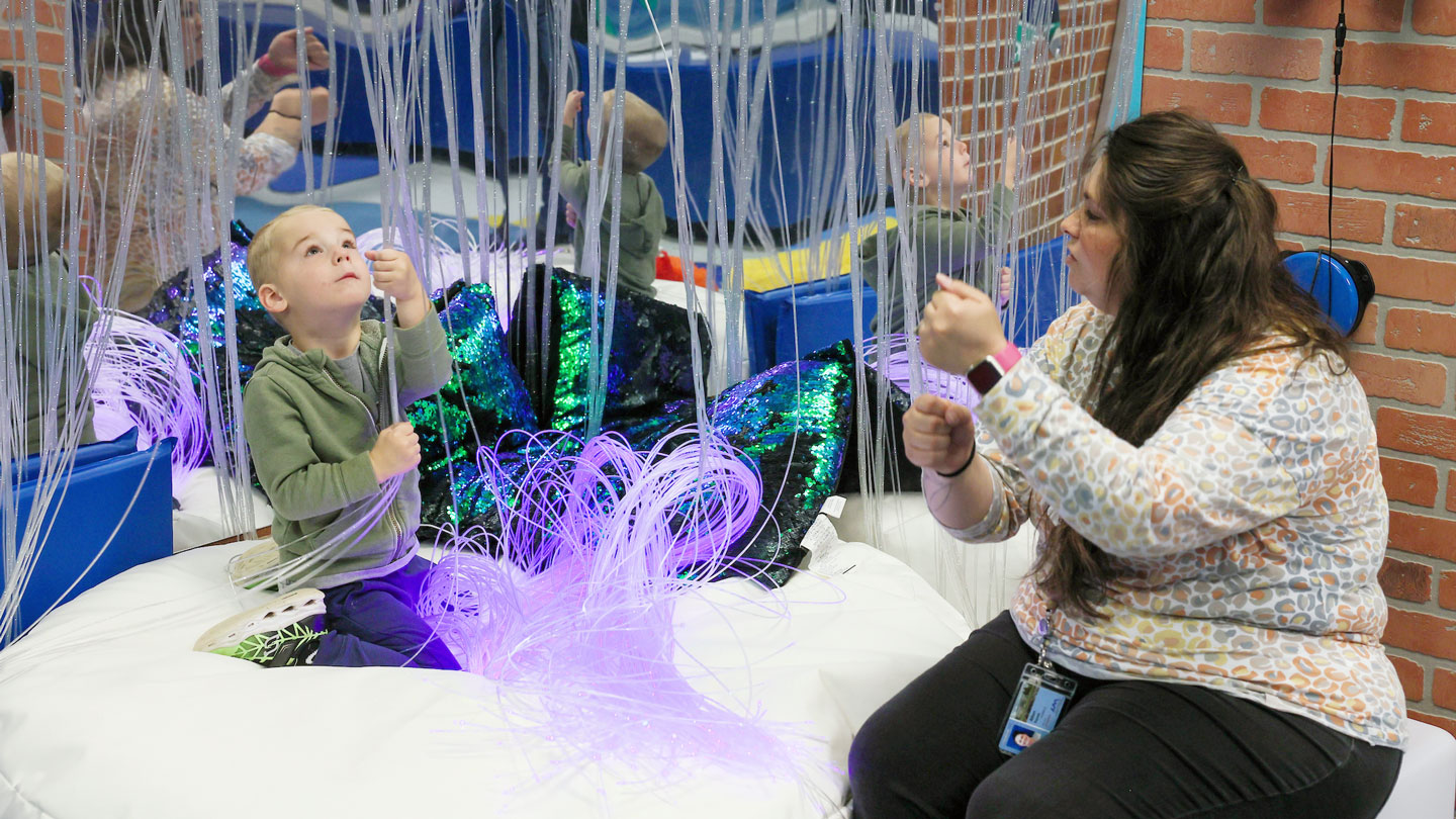 a teacher works with a student in UAH's sensory learning room