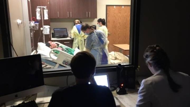 Nursing Faculty in the Simulation Control Room running a Healthcare simulation for nursing students.