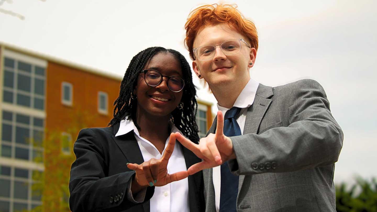 Chris Pinckard (right), President of the Student Government Association at the University of Alabama in Huntsville, stands next to Lori Hutchison, who is Vice-President of the Student Government Association at the University of Alabama in Huntsville. Together, they join hands to form the letters UAH. 