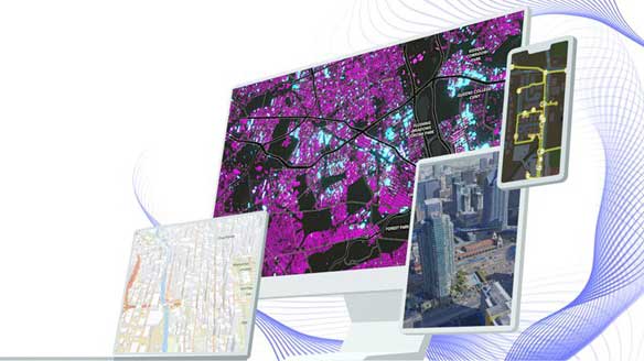Three computer screens display various maps: a vibrant urban map, a detailed city layout, and an aerial view of a metropolis.