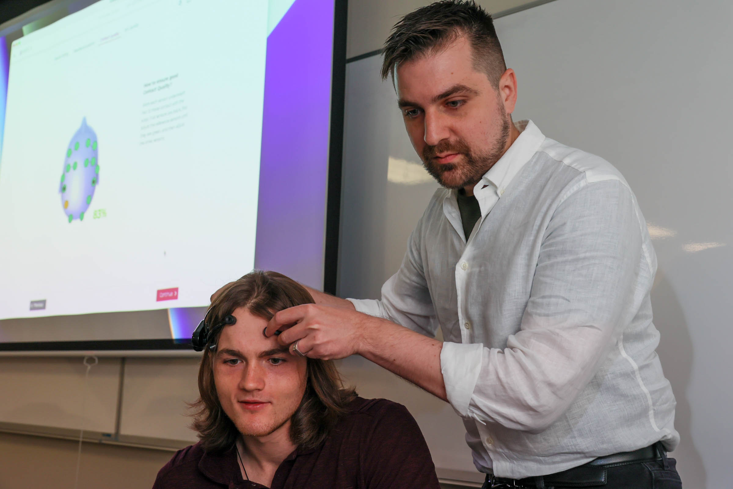 Warren de Wit setting up data collection for another student's neural patterns, which he then uses to train an AI in his research​.