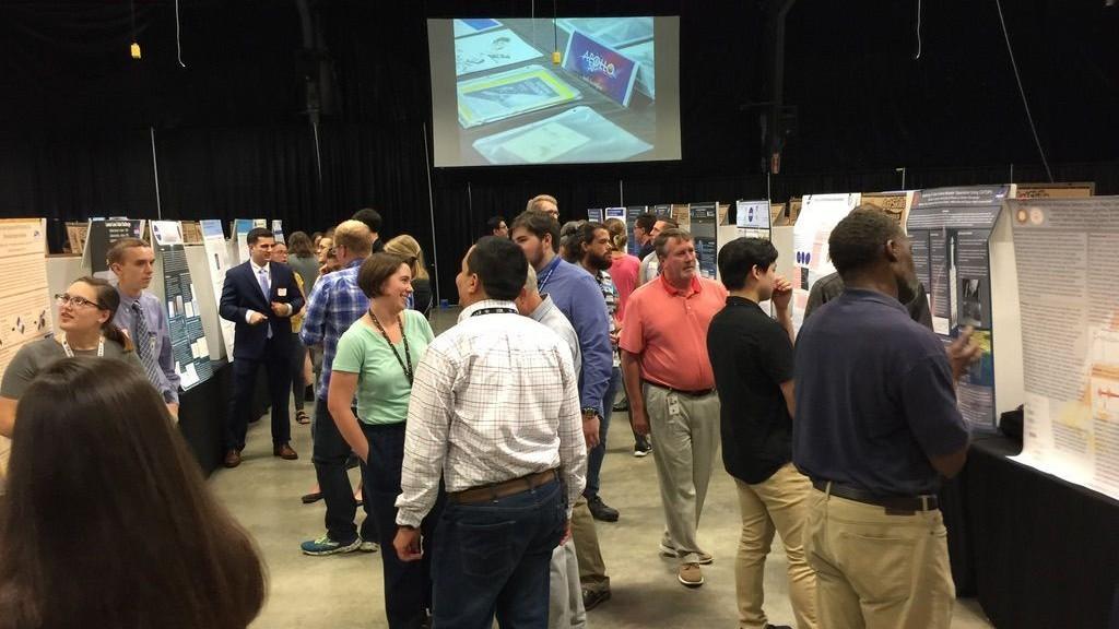people examine booths at a convention
