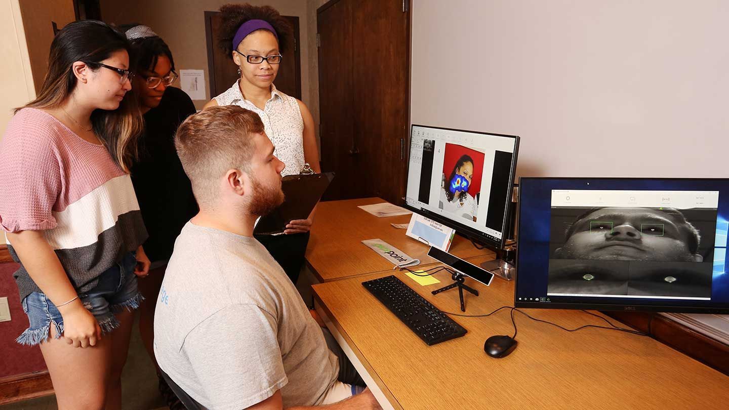 a group looks at a monitor of eye tracking data