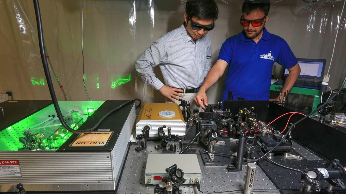 two people examine electronics