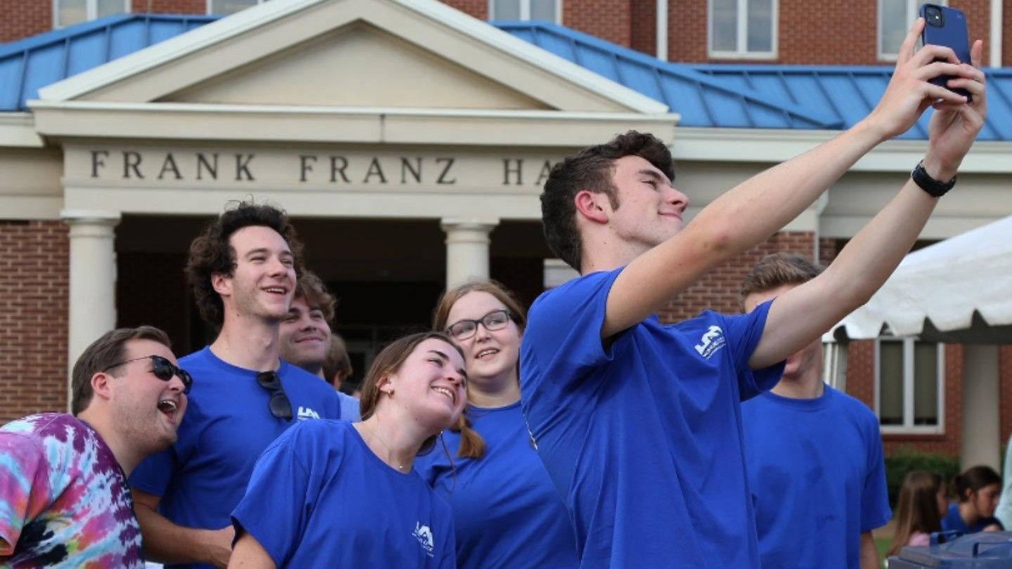 a student takes a selfie with many others