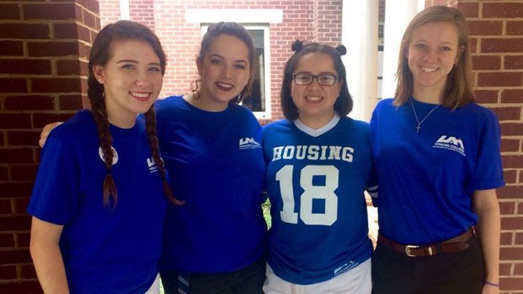 four women in honors attire pose