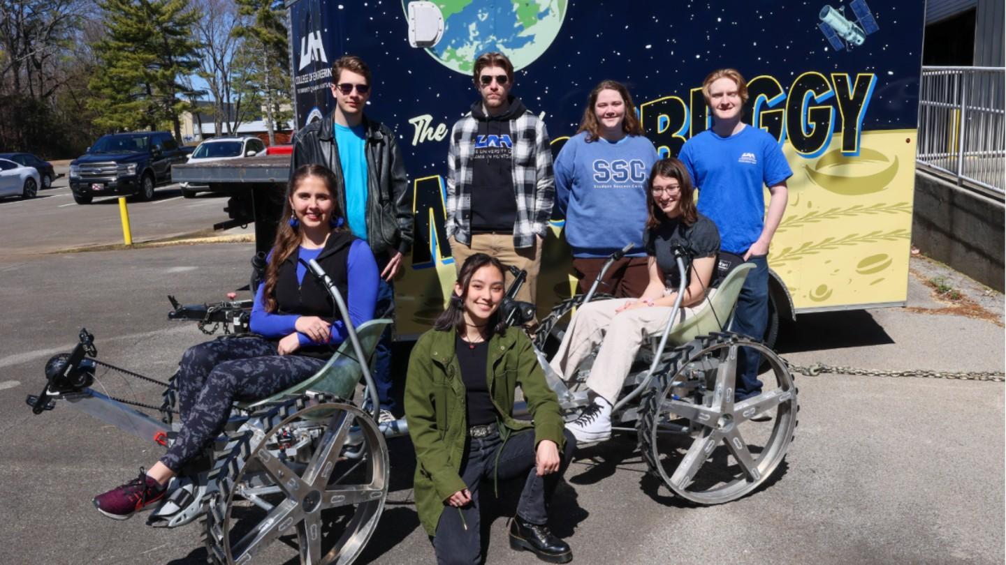 Honors students posing with the moon buggy that they worked on