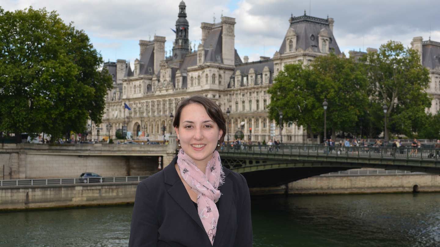 a woman stands in front of a river