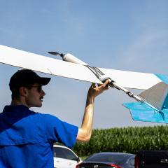 Photography example of a man about to launch a cardboard aircraft