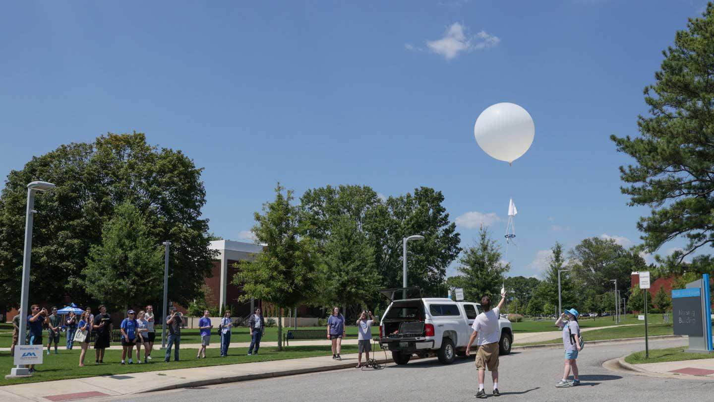 Atmospheric and Earth Science students launch a weather balloon during a Week of Welcome event.