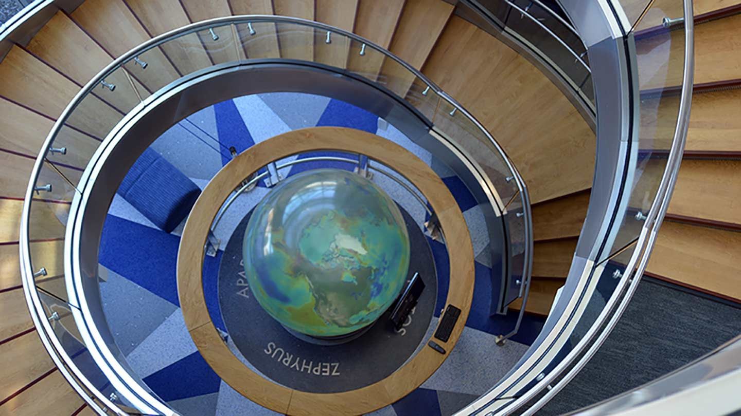 a spiral staircase with glass rails going down
