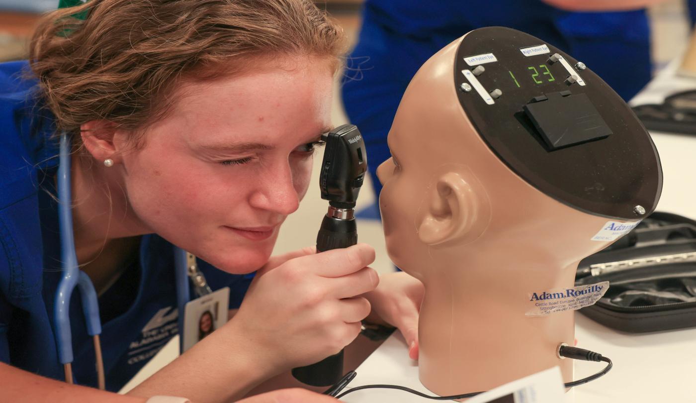 A student using a digital eye trainer to practice clinical eye examination skills. ABSN-NUR-18-