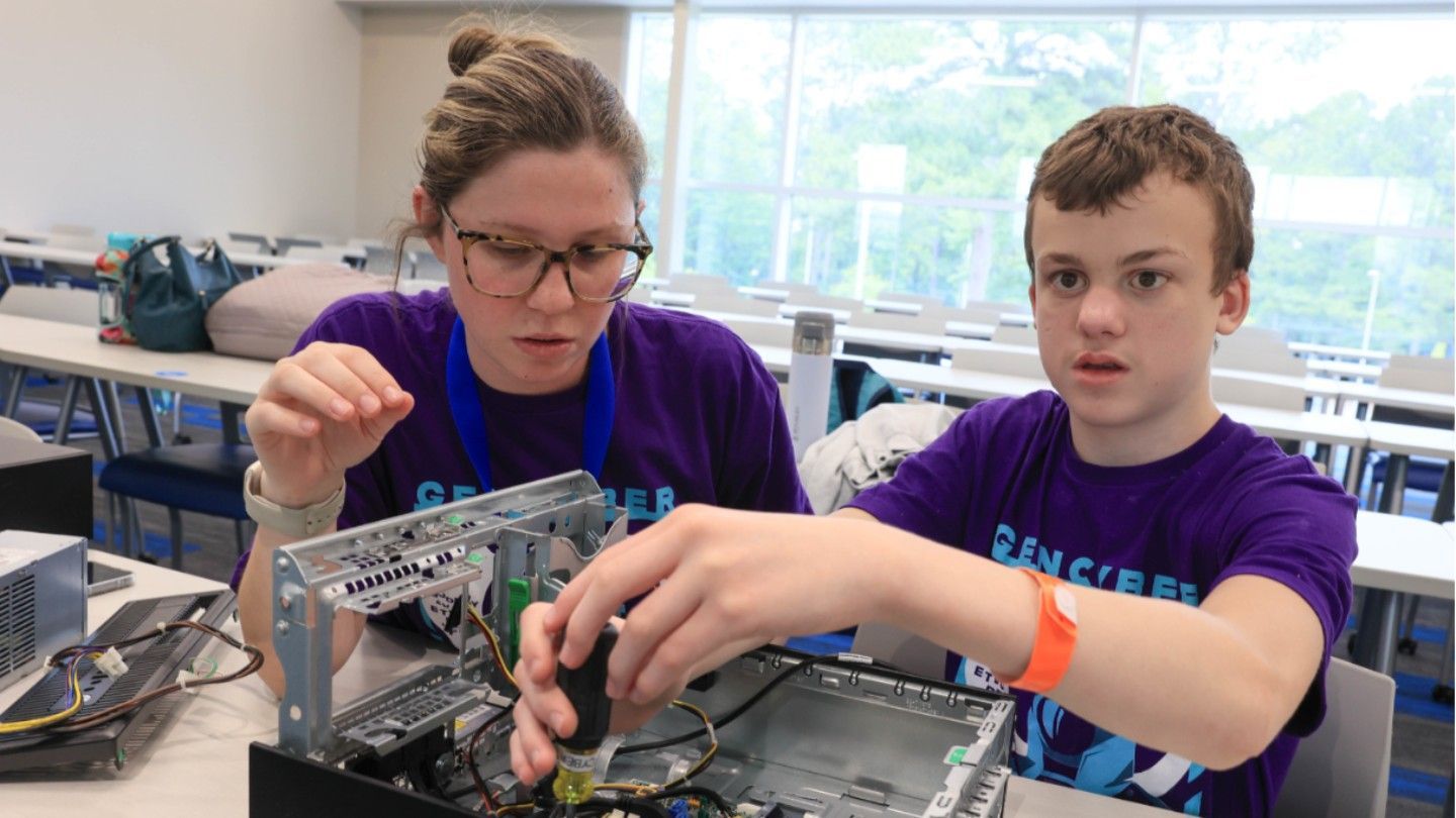 M.Ed. student supporting camper with computer hardware