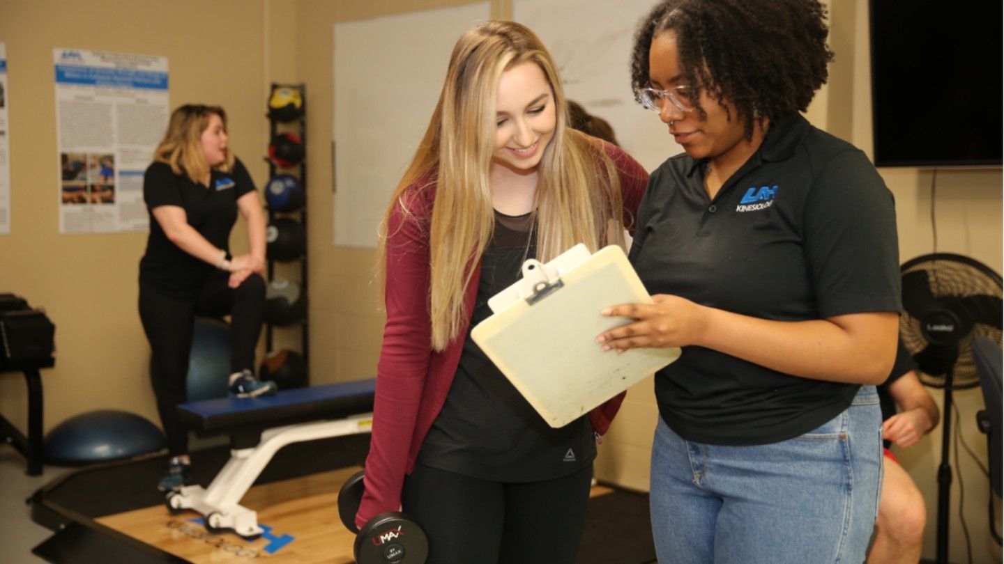 a woman shows another woman a clipboard