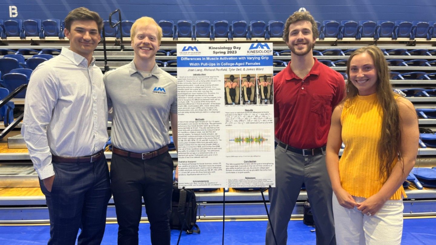 four people stand in front of a presentation