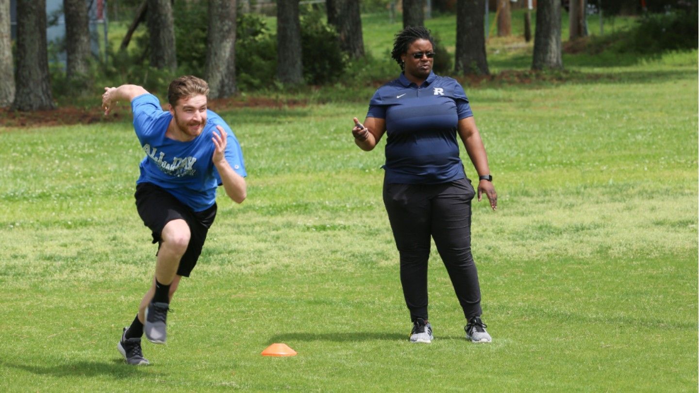 a man runs while a woman watches