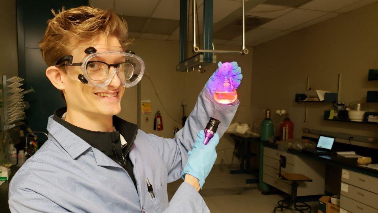 Cameron Sawyer holds a beaker