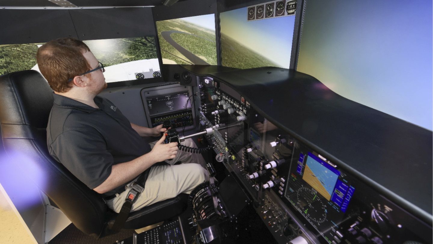 a man looks at a flight simulators many monitors