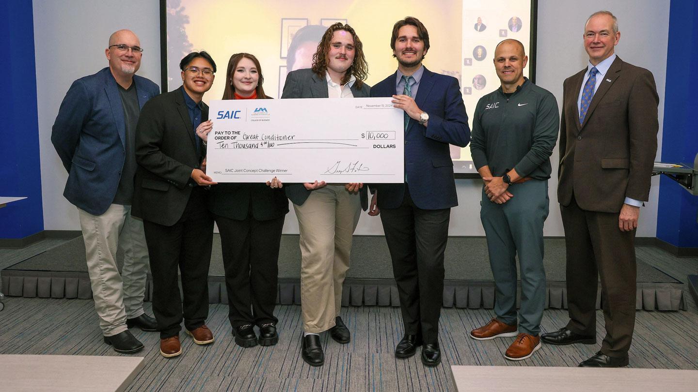 A group of UAH student researchers and entrepreneurs accept a reward at an innovation competition.