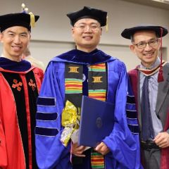 happy people in commencement robes and caps