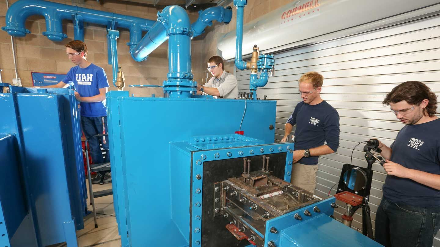 several people adjust a wind tunnel