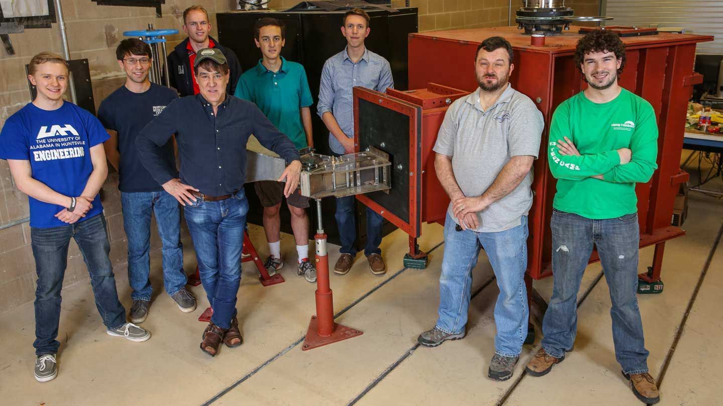 people stand in front of a wind tunnel