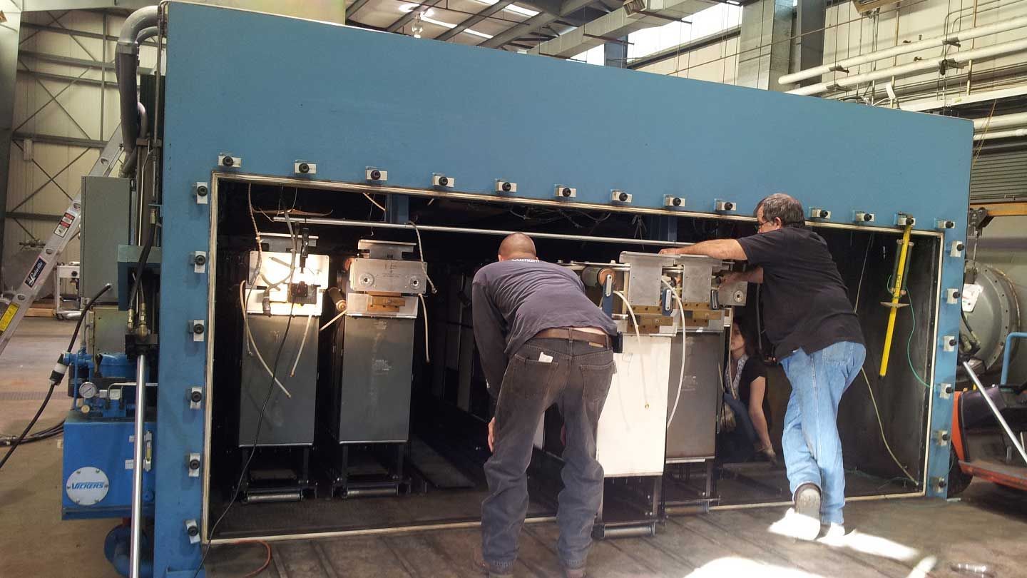 a large machine is inspected by three people