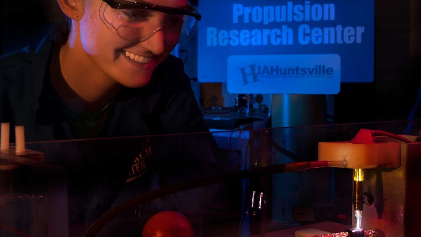 a woman smiles gleefully at a laser