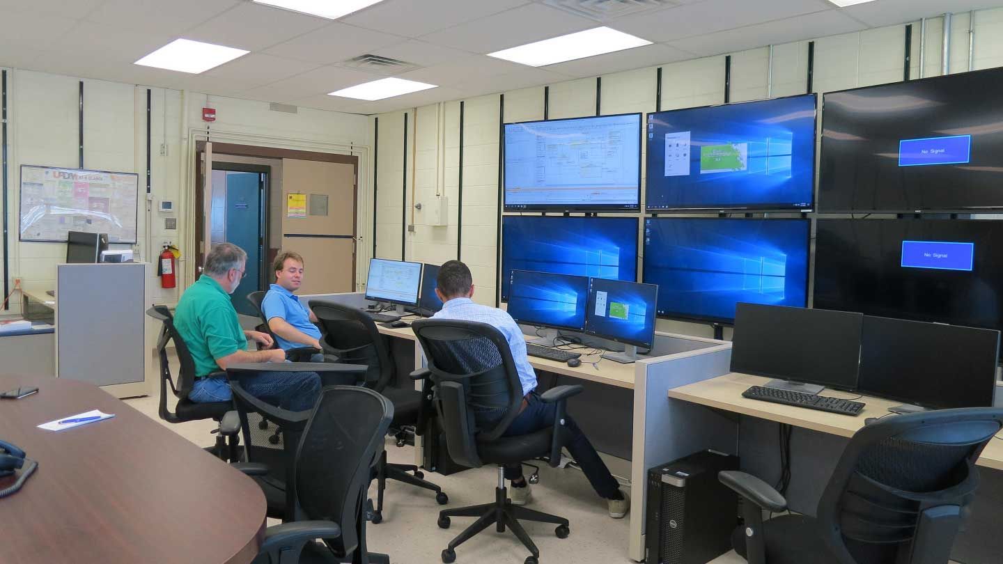 several people examine many screens