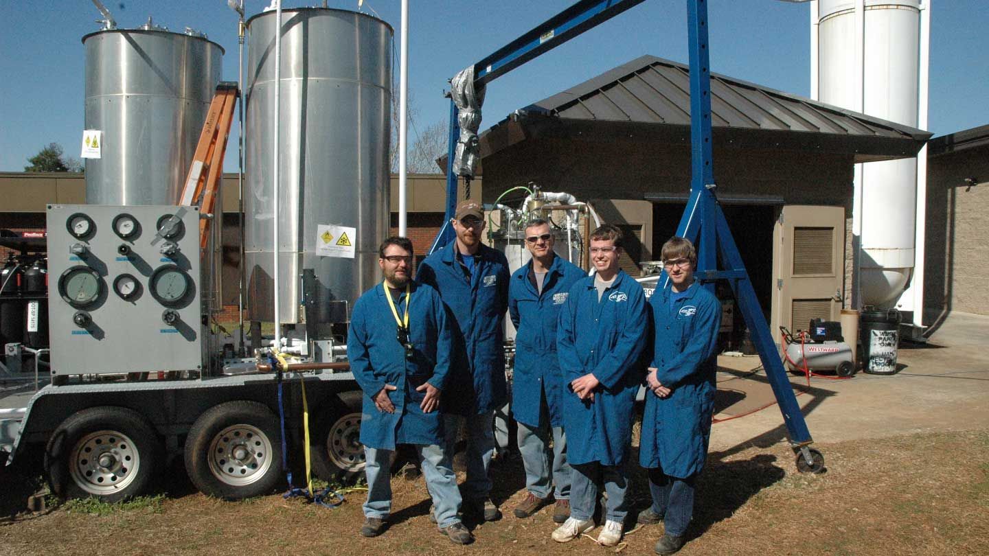 a test team stands in front of a large machine