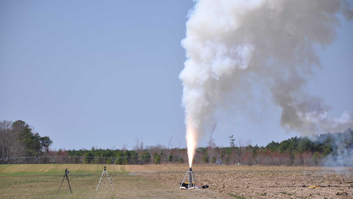 a rocket thruster fires in a field