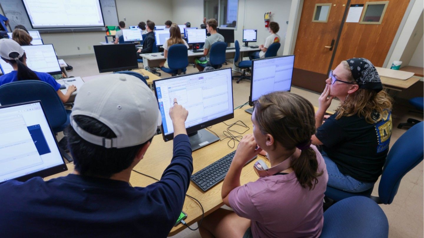 students help each other to learn on computers