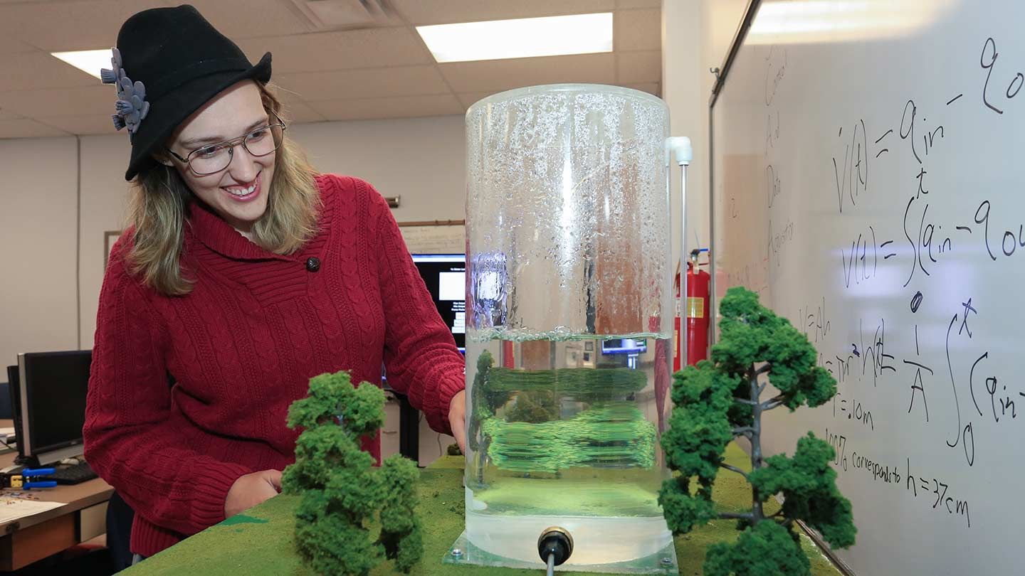 a woman smiles at a water model