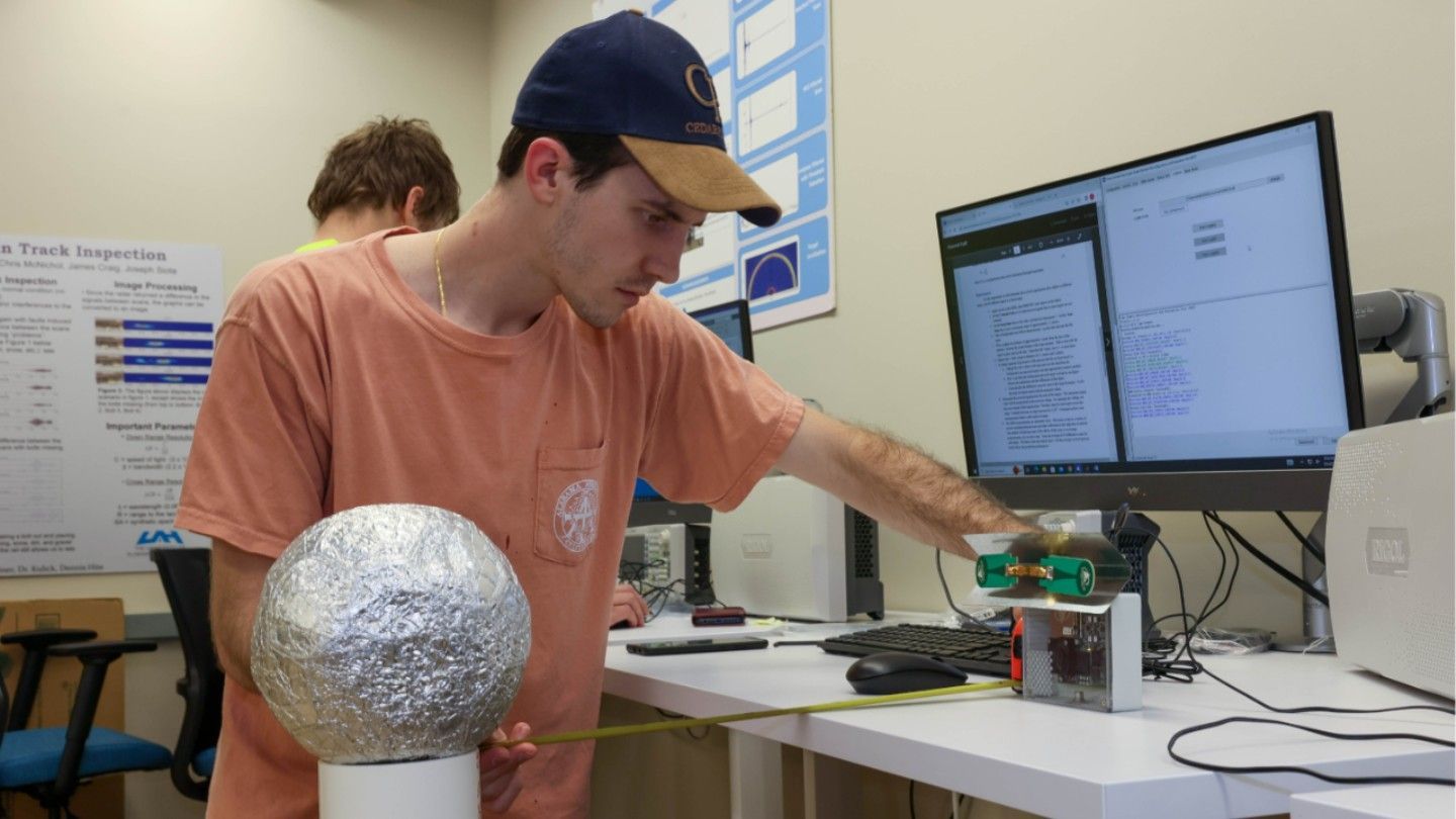 a student uses measuring equipment on a metal ball