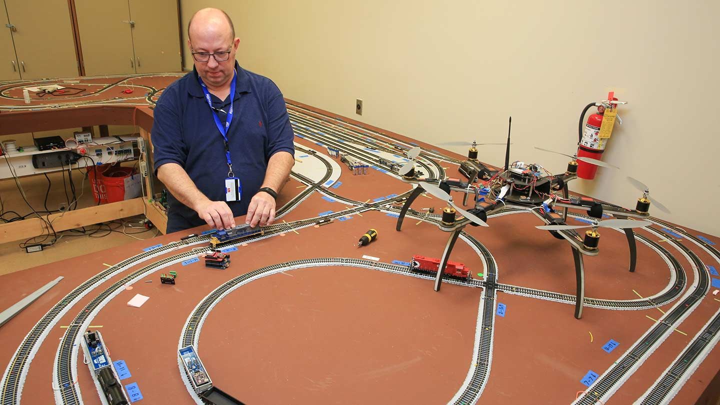 a man uses model train tracks