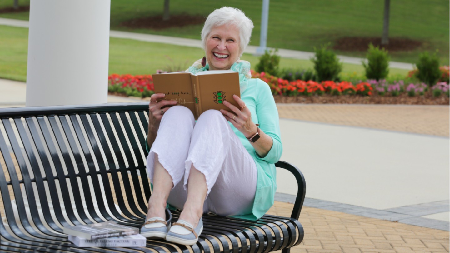 Betty Koval enjoys a book on the UAH Greenway.