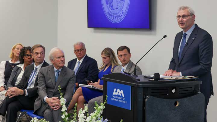 Dr. Leo giving a speach with guests chatting