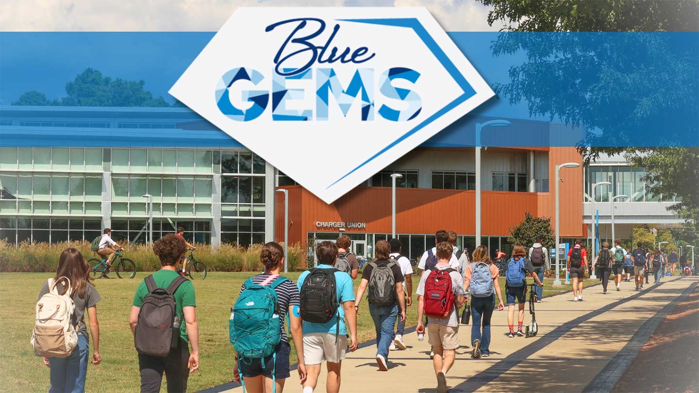 a group of UAH students representing Blue Gems Society walking in front of a building