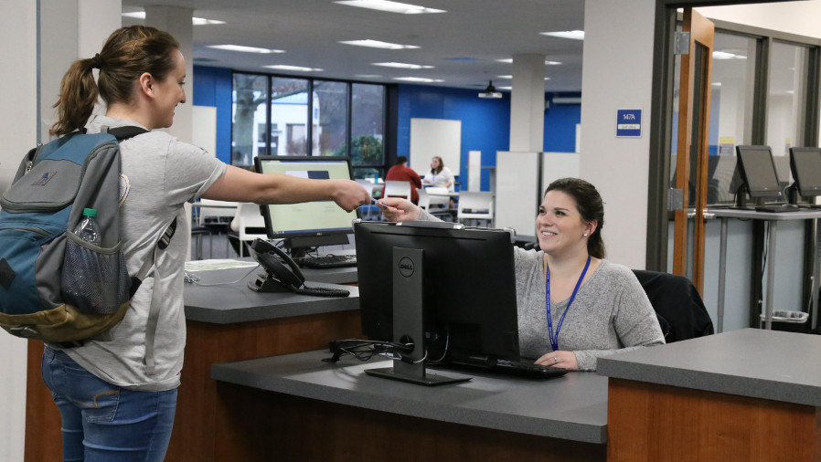 a UAH housing desk assistant helps a student