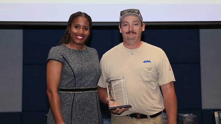 Dr. Kristy Lee, left, presents the Facilities Excellence Award to Dale Thompson.