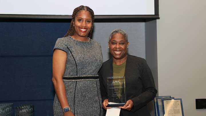 Dr. Kristy Lee, left, presents the Staff Leadership Excellence Award to Valarie King.