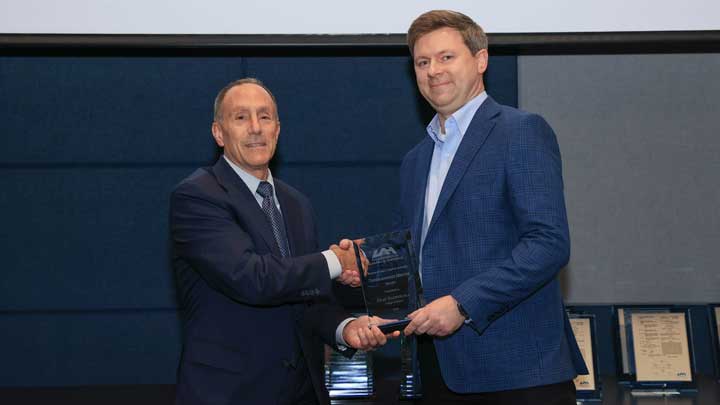 Dr. David Puleo, left, presents the Research and Creative Activity Undergraduate Mentor Award to Dr. Olaf Nachtigall.