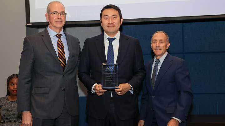 Dr. Chaehyun “Chad” Pyun, center, receives the Outstanding Faculty Award for the College of Business from Dr. Jason Greene, left, dean of the college, and Dr. David Puleo.