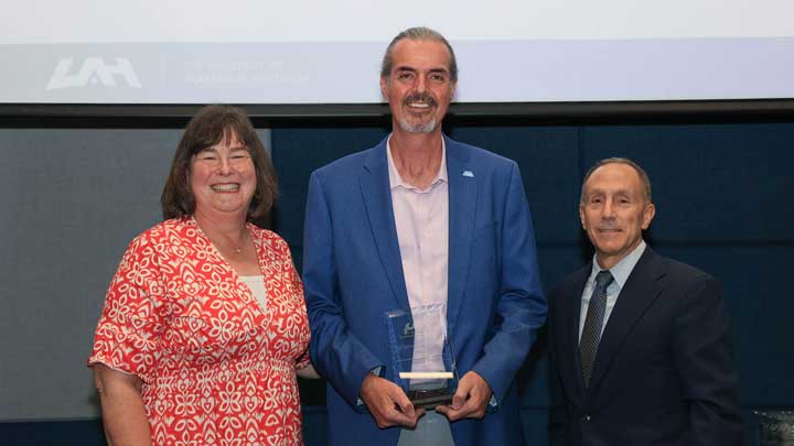 Dr. David Kyle, center, receives the Outstanding Faculty Award for the College of Education, Sport, and Human Sciences from Dr. Beth Quick, dean of the college, left, and Dr. David Puleo.
